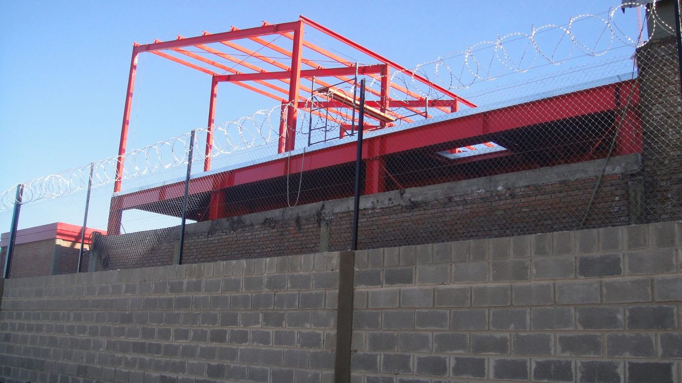 Muro perimetral de hormigón con cerramiento de seguridad en planta logística
